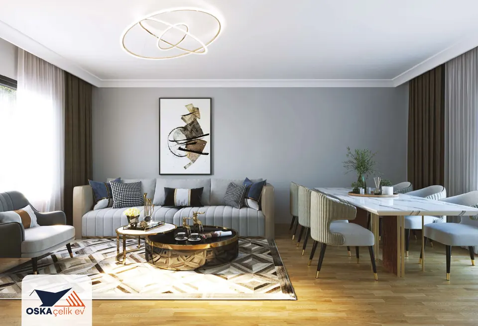 Gri duvarlı salonda üçlü koltuk, berjer, yuvarlak sehpa ve geometrik desenli halı; sağda mermer görünümlü uzun yemek masası ve döşemeli sandalyeler, tavanda iç içe halkalı avize.